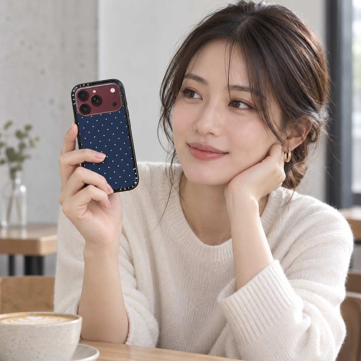 Japanese model holding Navy Dots case, illustrative