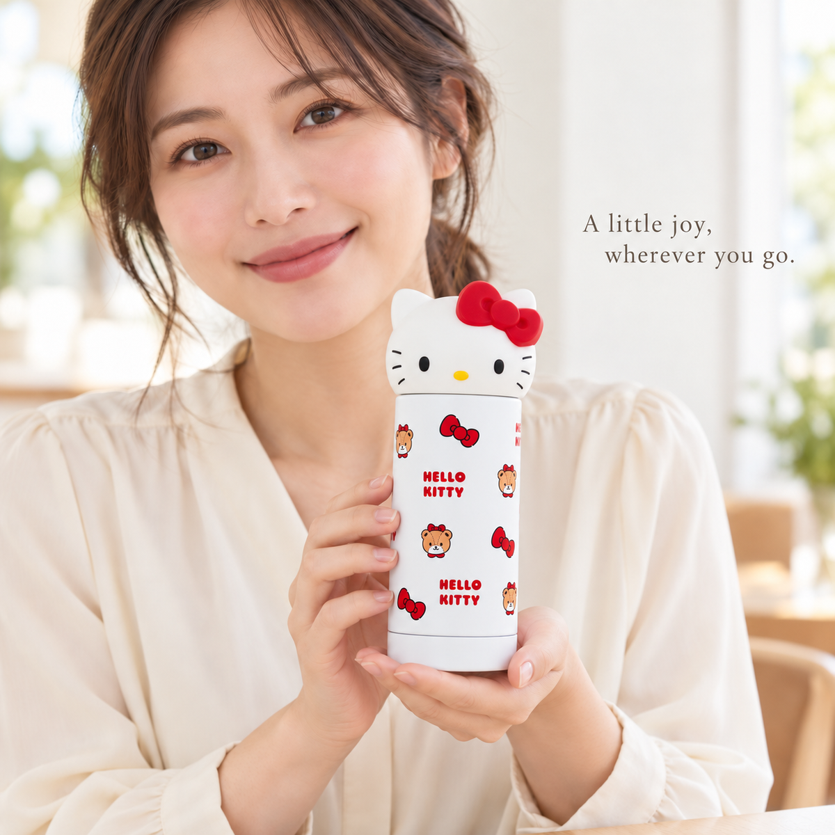 Hello Kitty bottle held by a model, front-facing Kitty lid