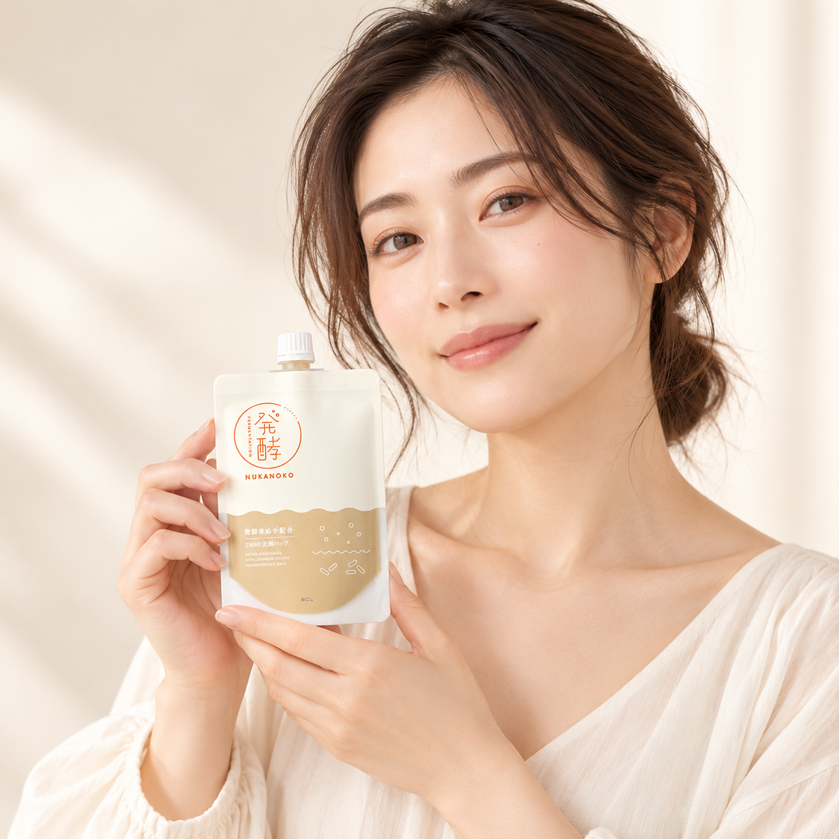 Japanese woman holding NUKANOKO face wash pouch
