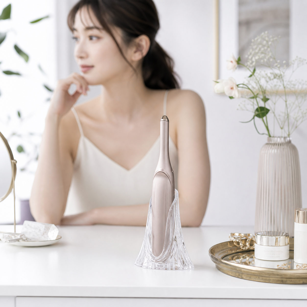 ReFa BEAUTECH FINGER IRON placed in a clear faceted holder on a vanity table