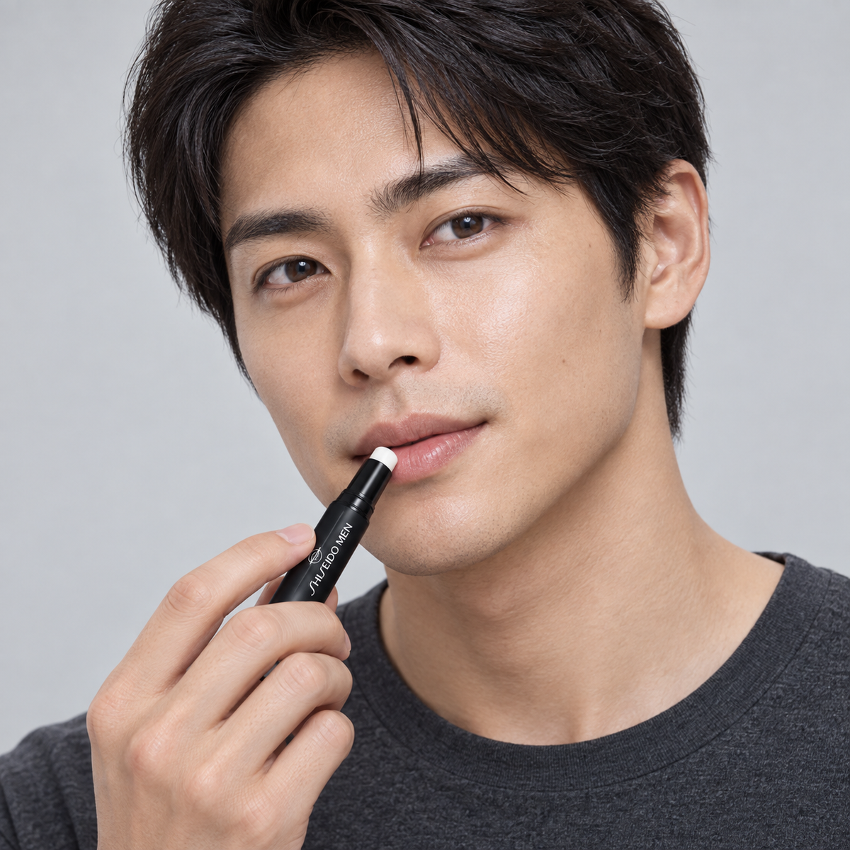 Homem japonês aplicando SHISEIDO MEN Moisturizing Lip Creator