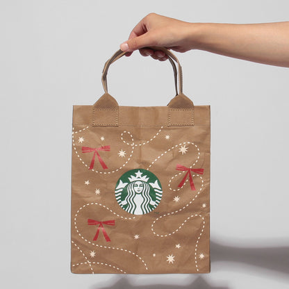 Holiday 2026 shopper bag carried by its paper handles